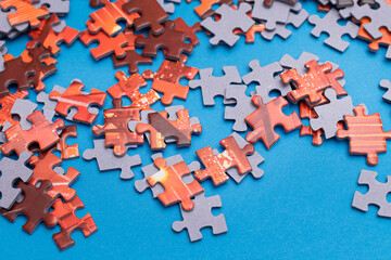 Mixed Peaces of a Colorful Jigsaw Puzzle Lie on the Blue Background - Strategy and Solving Problem Concept