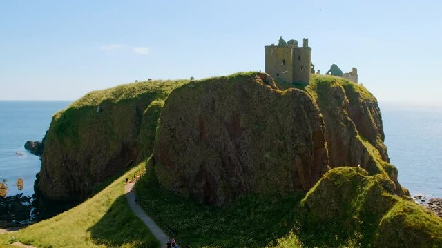 Cinematic view of the Dunnottar Castle, a medieval fortress on a rocky headland off the coast of Scotland, UK dating to 1400