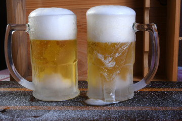 delicious mug of super cold and refreshing draft beer on the table in the blurred background