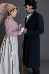 A Regency couple together against a grey backdrop