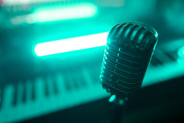 Retro microphone and midi keyboard synthesizer in record studio.