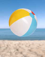 Fototapeta na wymiar Colorful inflatable beach ball and seascape on background