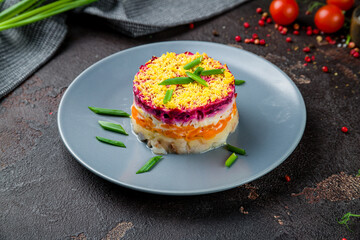 salad herring under fur coat on blue plate on dark concrete table