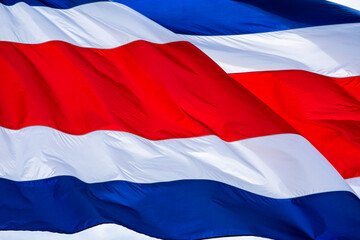 Primer plano de una bandera de Costa Rica ondeando con un viento fuerte - obrazy, fototapety, plakaty