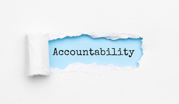 The text Accountability appearing behind torn yellow paper