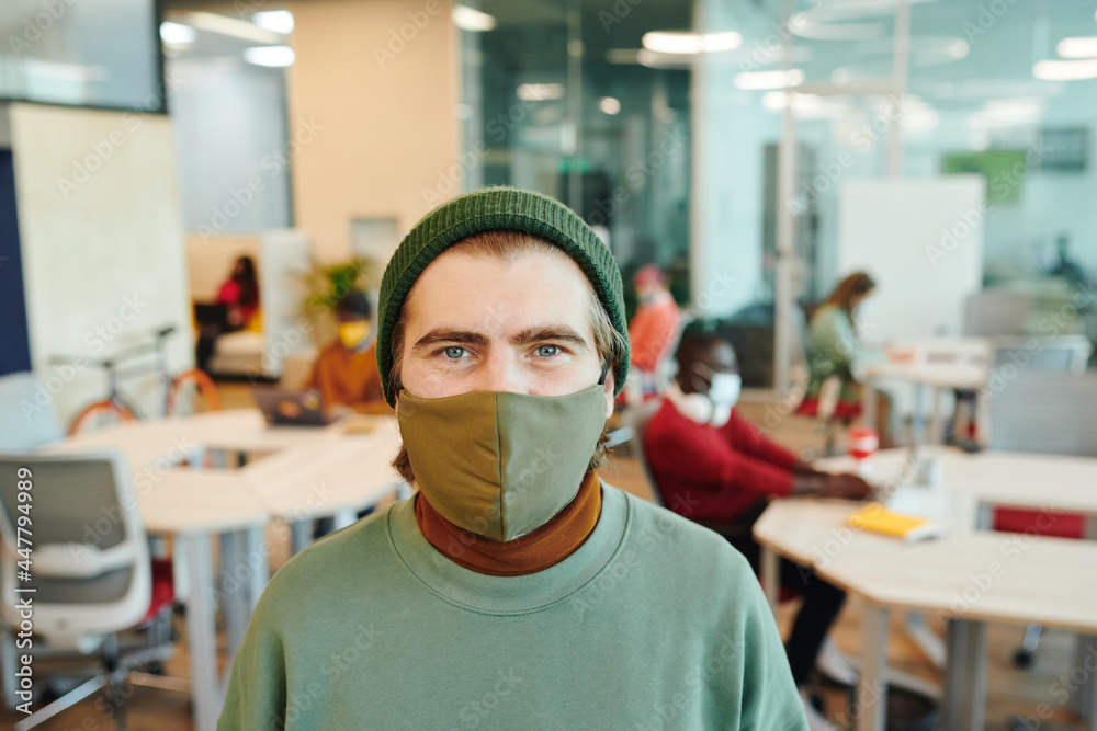 Wall mural bearded male office manager with bicycle looking at you while standing by desk