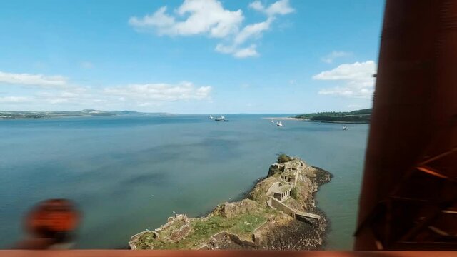 Crossing the Firth of Fourth in Scotland, UK along the famous Forth Railway Bridge overlooking the Inchgarvie island. The Forth Bridge was inscribed as a UNESCO World Heritage Site