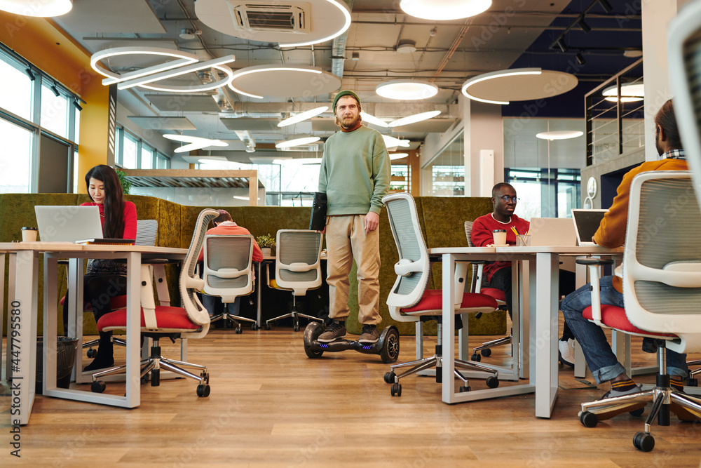 Canvas Prints bearded office manager holding bicycle while moving between desks of colleagues