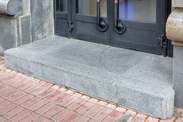 a threshold with a doorstep at the threshold entrance to the store with a black iron door with...