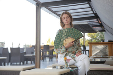 Young woman in bar drinking cocktail