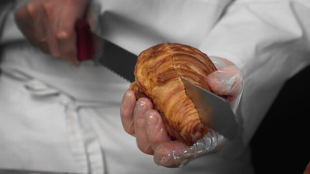 Chef cuts croissant to make sandwich