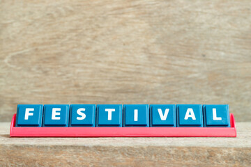 Tile alphabet letter with word festival in red color rack on wood background
