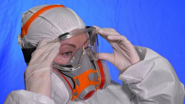 Scientist virologist in respirator. Slow motion. Woman close up look wearing protective medical mask. Concept health safety N1H1 virus protection coronavirus epidemic 2019 nCoV. Chroma key blue film.