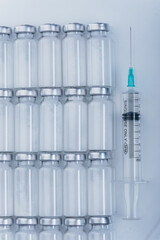 Medicine, Injection, vaccine and disposable syringe, drug concept. Sterile vial medical syringe needle. Macro close up. Glass medical ampoule vial for injection. Bottles ampule with aluminum cap.