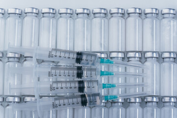 Medicine, Injection, vaccine and disposable syringe, drug concept. Sterile vial medical syringe needle. Macro close up. Glass medical ampoule vial for injection. Bottles ampule with aluminum cap.