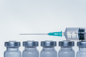 Medicine, Injection, vaccine and disposable syringe, drug concept. Sterile vial medical syringe needle. Macro close up. Glass medical ampoule vial for injection. Bottles ampule with aluminum cap.