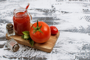 tomato juice and tomato on a wooden stand.