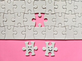 Jigsaw Puzzle Pieces on a pink background with happy puzzle and sad puzzle to portray how woman should choose their life.