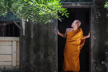 buddhist novice monk standing at door in buddist temple