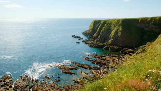 Sweeping view of the stunning northeastern coast of Scotland, featuring the Dunnottar Castle, a medieval fortress dating to 1400