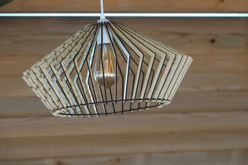 vintage lamp with wooden frame hanging on wooden ceiling