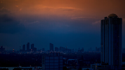 The high angle background of the city view with the secret light of the evening, blurring of night lights, showing the distribution of condominiums, dense homes in the capital community