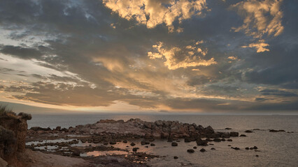 Obraz premium sea cliffs at sunset, reflection of mountain and sea