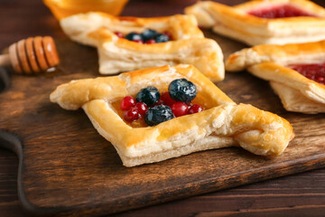 Board with danish pastry on wooden background