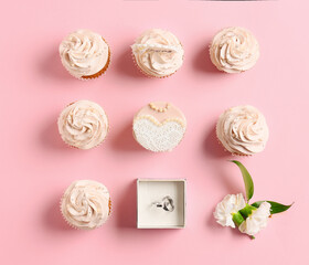 Composition with cupcakes and wedding rings on color background