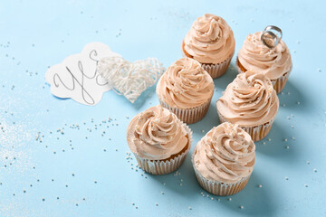 Tasty cupcakes and wedding rings on color background