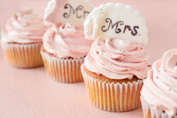 Tasty wedding cupcakes on color background