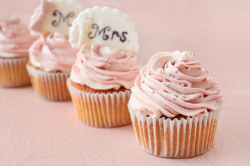 Tasty wedding cupcakes on color background