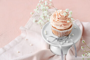 Dessert stand with tasty wedding cupcake on color background