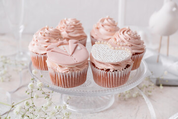 Dessert stand with tasty wedding cupcakes on table