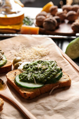 Tasty toast with pesto sauce on table, closeup