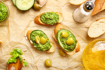 Tasty toasts with pesto sauce and olives on table, closeup