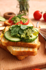 Tasty toasts with pesto sauce on table, closeup