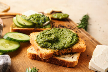 Tasty toasts with pesto sauce on color background, closeup