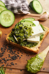 Tasty toast with pesto sauce on table, closeup