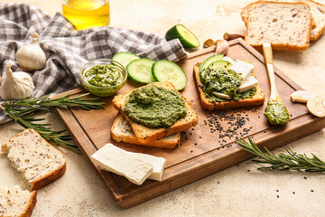 Tasty toasts with pesto sauce on table