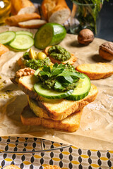 Tasty toasts with pesto sauce on table, closeup