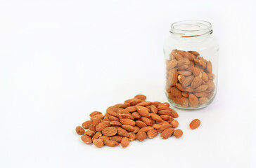 Almonds nuts and glass bottle isolated on a white background