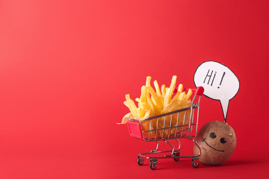 Creative composition with tasty french fries in shopping cart, potato and word HI on color background