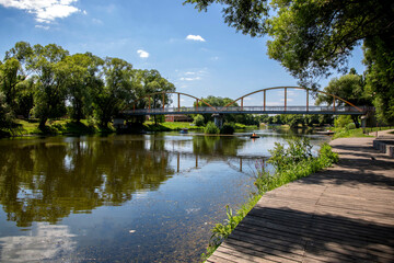 Fototapeta na wymiar View of the Bridge Over The Vezelka River In Victory Park In The Center of Belgorod