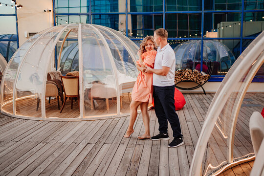 a man and a woman in love dance to a rooftop cafe on a date.