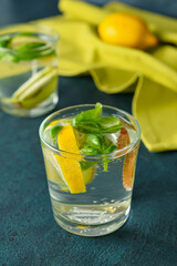 Glass of tasty lemonade with basil on dark background