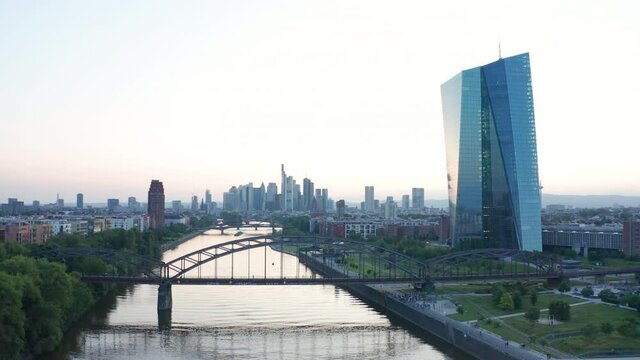 Drone aerial panorama shot European Central Bank Frankfurt Europ&auml;ische Zentralbank EZB ECB with fly up with the skyline sunset