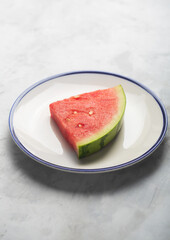 One watermelon piece on the plate, side view