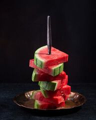 Red raw watermelon pieces on black background