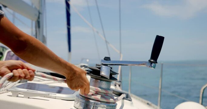 Unwinding Sailboat Rope on Winch, Close Up Detail of Sailman Hands and Sailing Equipment